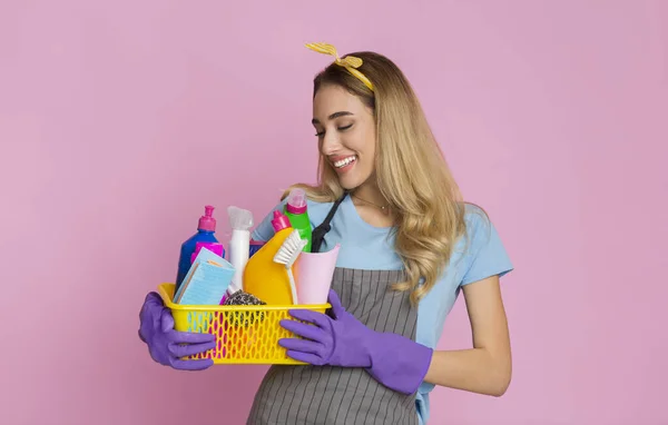 Young beautiful housewife holding box with detergents — Stock Photo, Image