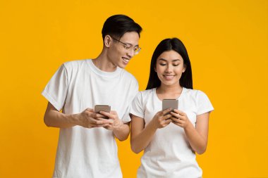 Asyalı adam, kız arkadaşını akıllı telefondan izliyor.