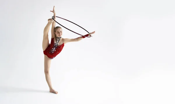 Young girl in bright sports clothes performing exercise with hoop on white background, blank space — Stock Photo, Image