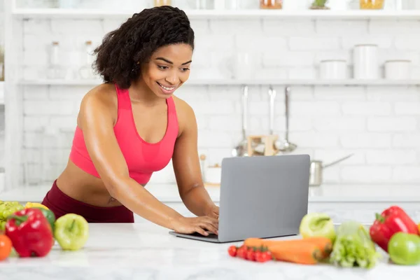 Ragazza nera utilizzando computer portatile alla ricerca di nuove ricette — Foto Stock