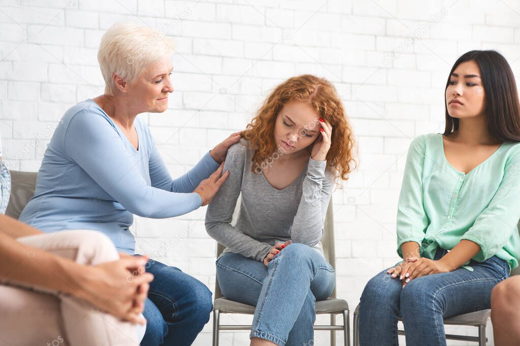 Psychologist Supporting Depressed Girl During Group Therapy Indoor