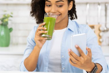 Afro Kız Meyve Smoothie içiyor ve Sosyal medyayı kontrol ediyor