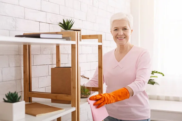 Senior dame die meubels schoonmaakt in haar appartement — Stockfoto