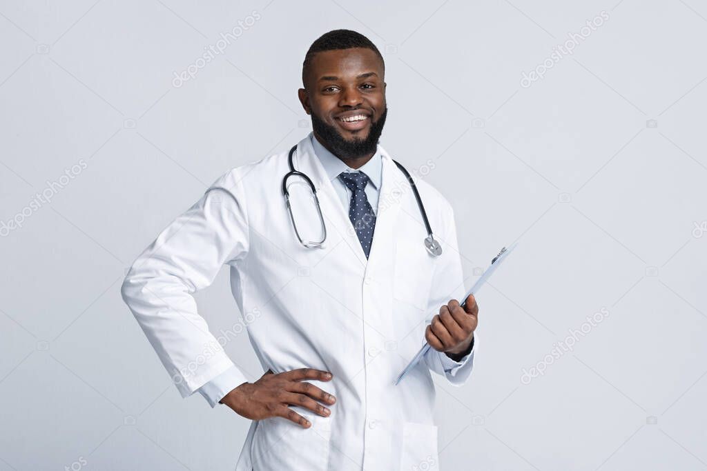 Happy african male therapist holding medical chart