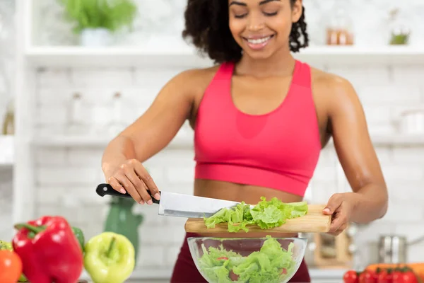 Красивая молодая черная девушка готовит овощной салат дома — стоковое фото
