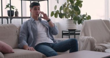 Milenyum adamı evde cep telefonuyla konuşuyor.