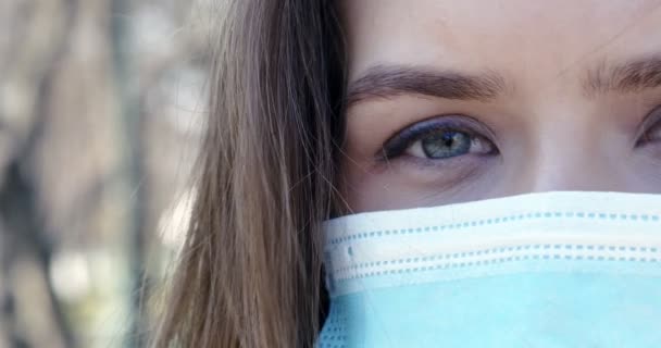 Portret van een jonge vrouw met een beschermend masker buitenshuis — Stockvideo