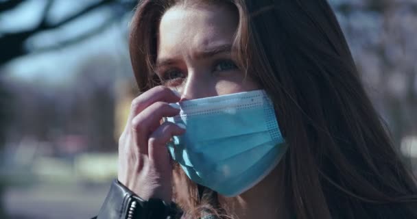 Ung kvinna tar av medicinsk mask, andas djupt utomhus — Stockvideo