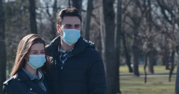 밖에서 보호 마스크를 쓴 채서 있는 젊은 남녀 — 비디오