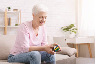 Karantina sırasında Rubiks küpüyle oynayan son sınıf öğrencisi kadın.