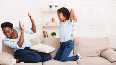 Afro anne ve kızı yastık savaşı yapıyor.
