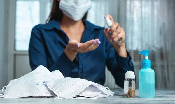 Chica en máscara usando spray desinfectante en casa — Foto de Stock