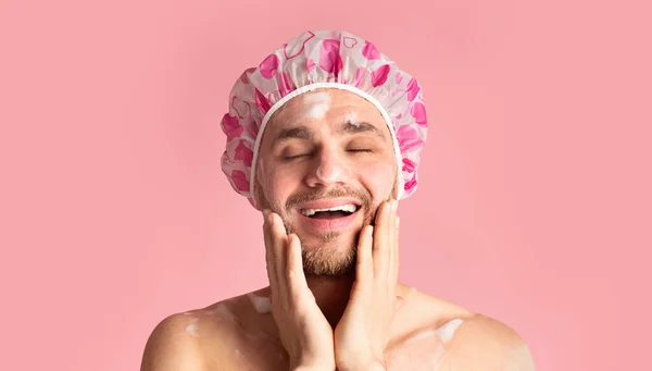 Chico divertido en gorra de ducha lavándose la cara — Foto de Stock