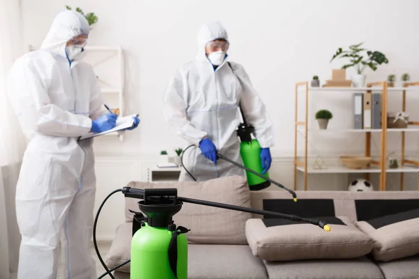 Мужчины в защитных костюмах уборка дома, эпидемия — стоковое фото