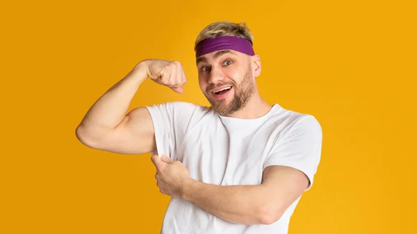 Grappige duizendjarige man toont biceps, vrije ruimte — Stockfoto