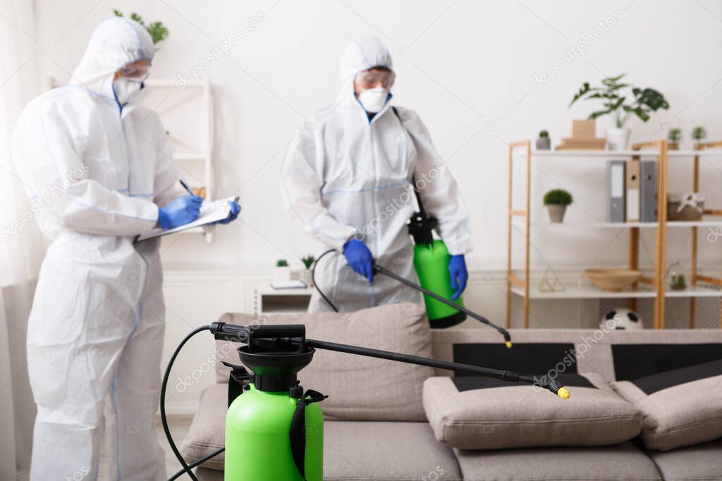 Men in hazmat suits cleaning home, epidemic