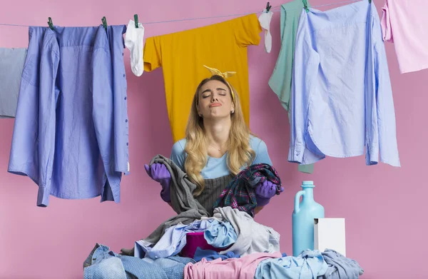 Fatigue woman looks away, stands near basket with pile of laundry — Stock Photo, Image