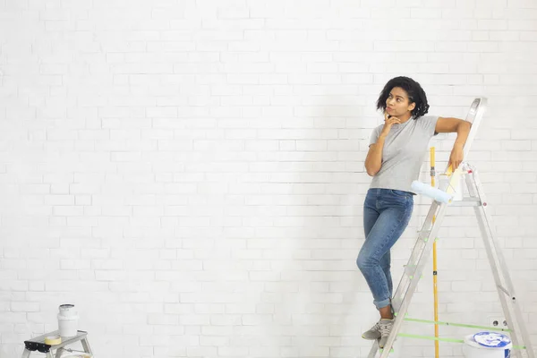 African american female coloring wall with paint roller — Stock Photo, Image