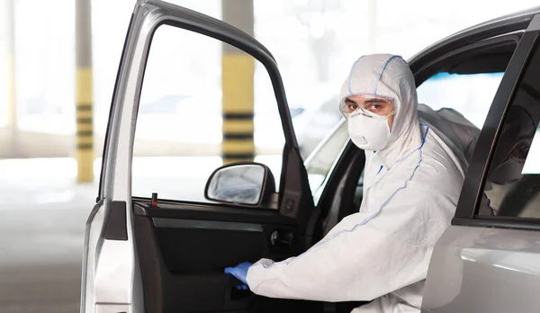 Mand i coronavirus dragt planlægger at køre med bil - Stock-foto
