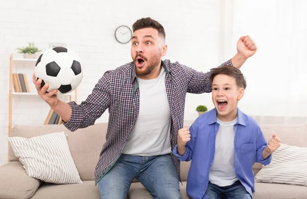 Pai emocional e filho com bola de futebol assistindo futebol — Fotografia de Stock