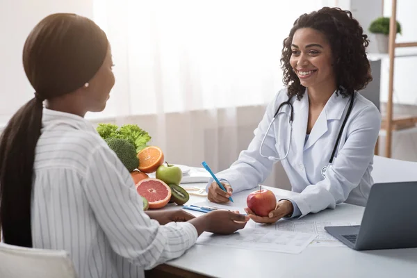 Nutricionista feliz dando consulta ao paciente sobre alimentação saudável — Fotografia de Stock