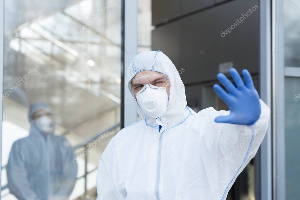 Man in protective hazmat suit stops, does not let to enter