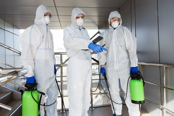 Homens em terno de proteção química pára a propagação do vírus — Fotografia de Stock