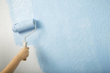 Yeni tasarım. Kız duvarları boyuyor.