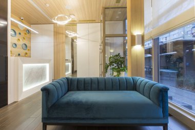 Çocuk dişçiliğinin bekleme alanında büyük mavi yumuşak kanepe