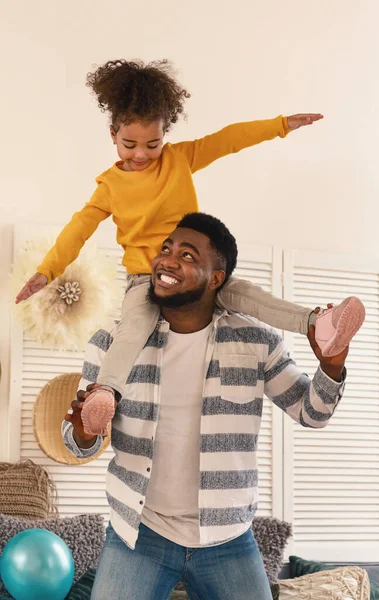 Afrikansk amerikansk pappa och dotter på sina axlar gör planet — Stockfoto