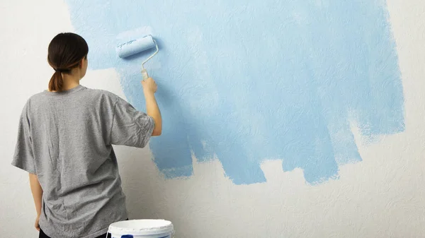 Frau bemalt Wand zu Hause, freier Raum — Stockfoto
