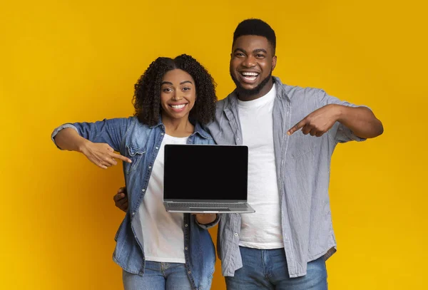 Situs web yang bagus. Pasangan hitam bahagia menunjuk laptop dengan layar hitam — Stok Foto
