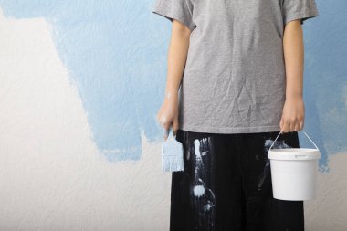 Duvarda duran silindirli ve kovalı kadın.