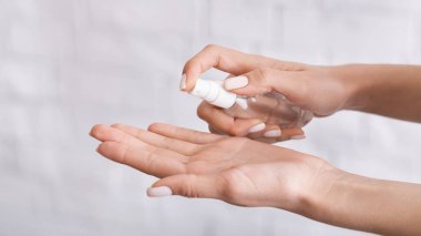 Koronavirüsten koruma. Kadın ellerine antiseptik sıkar..