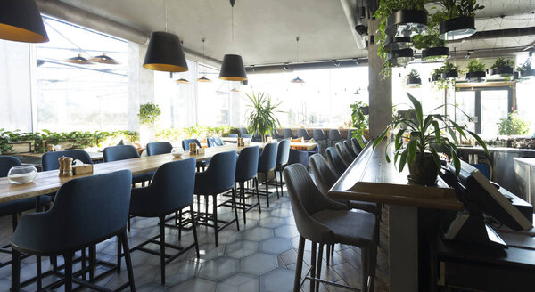 Empty cafe or bar interior with long table with chairs