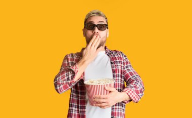 Üç boyutlu gözlüklü adam ağzını eliyle kapatıyor.