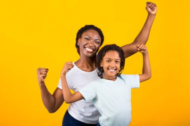 Korkak Afro-Amerikan kadın ve kız yumruklarını kaldırıyor.