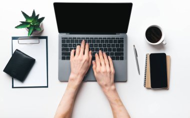 Orta yaşlı kadın elleri modern dizüstü bilgisayarda yazıyor.