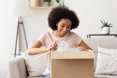 Afrikalı Amerikalı kız paketi satın alarak açıyor.