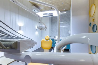 Modern, iyi donanımlı odadaki çocuk dişçi koltuğuna bakın.