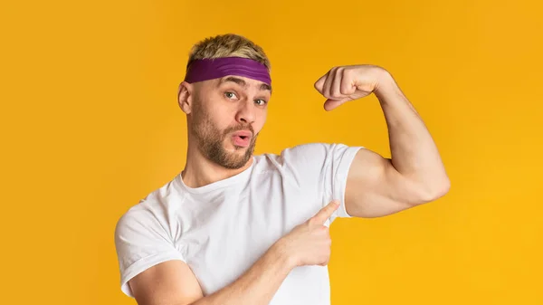 Sportergebniskonzept. Lustiger Mann zeigt Bizeps — Stockfoto