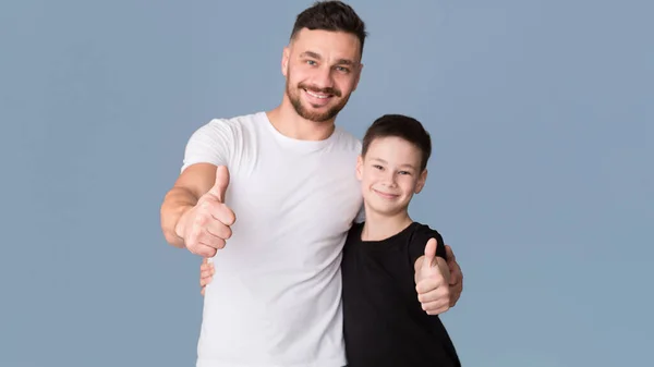 Vater und Sohn zeigen Daumen nach oben, grauer Hintergrund — Stockfoto