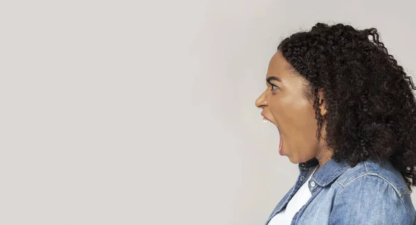 Boos Afro-Amerikaanse vrouw schreeuwend van woede op kopieerruimte — Stockfoto