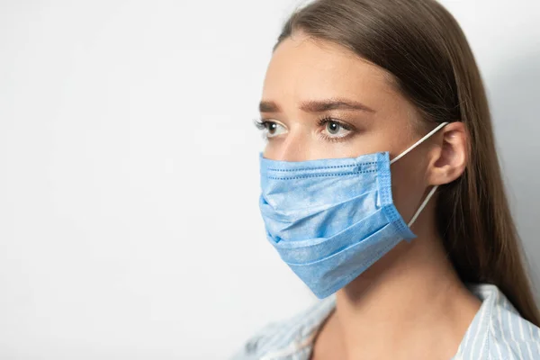 Menina vestindo máscara médica durante o surto de epidemia em fundo branco — Fotografia de Stock