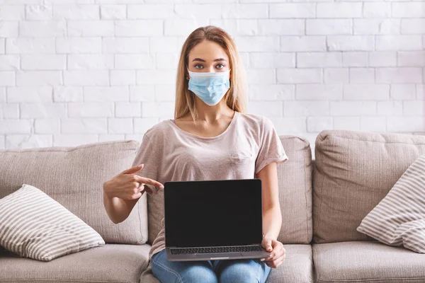 Girl shows blank laptop screen. Coronavirus concept — Stock Photo, Image