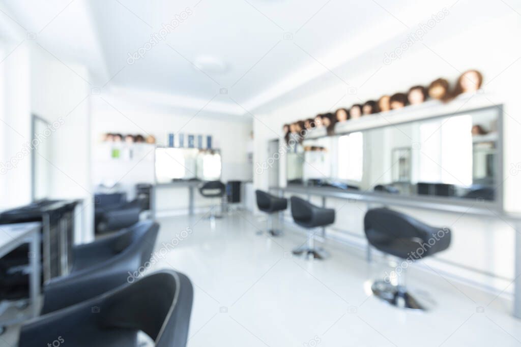 Blurred interior of beauty salon with large mirror