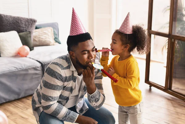 Afrikansk amerikansk familj i hattar blåser i femmor — Stockfoto