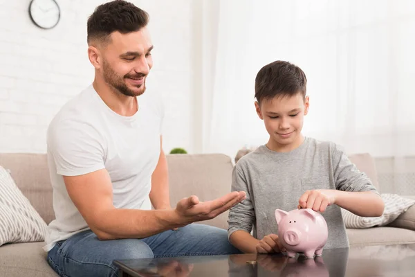 Papa apprend à son fils à économiser de l'argent à la maison — Photo