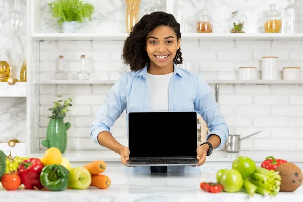 Afro ragazza che tiene il computer portatile in cucina — Foto Stock