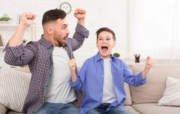Emocional papá e hijo viendo la televisión en casa, espacio libre — Foto de Stock